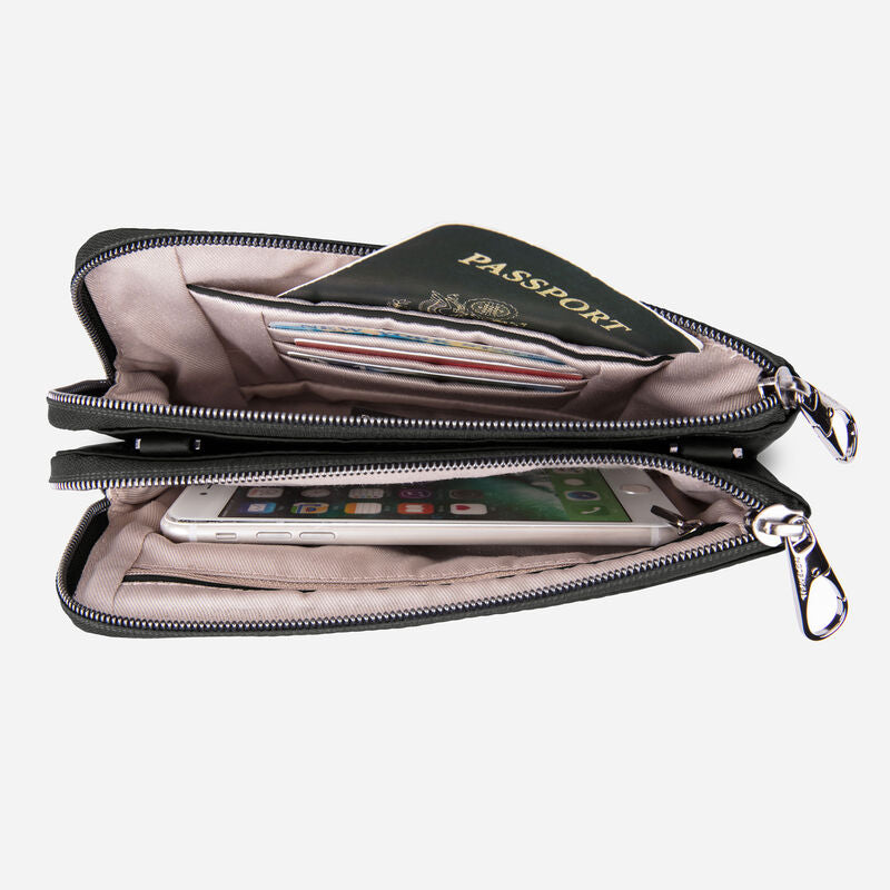 A view from the top looking down at a purse with two unzipped compartments.  The top compartment shows a passport and credit cards.  The bottom one shows a cell phone.