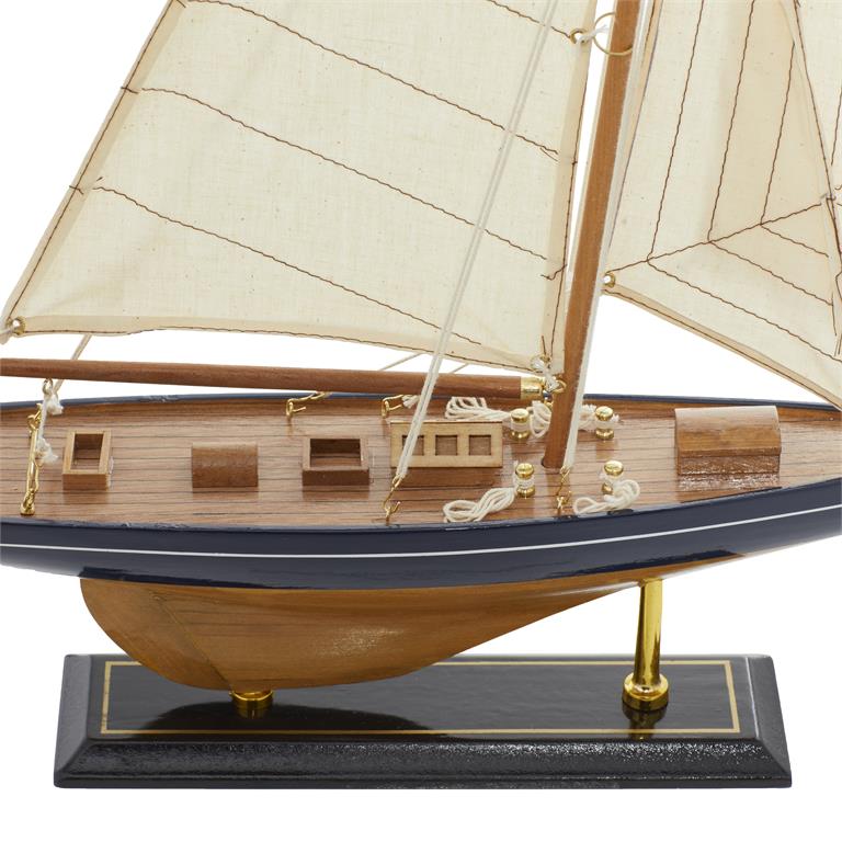 A close up image of the side of a wooden model sailboat.  The base is dark brown and has two vertical bras supports holding the hull of the boat.  The boat itself has a wide navy stripe running the length of the boat, and a thin white one just below the railing.  The sails are off white and have a thin pin stripe diagonal navy blue pattern. 