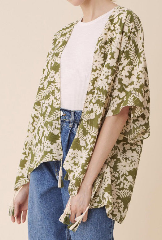 Front view of model wearing a green and white floral kimono over a white top and jeans.