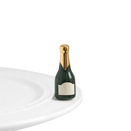 A ceramic champagne bottle with gold foil detail and blank label, attached to the edge of a tray.