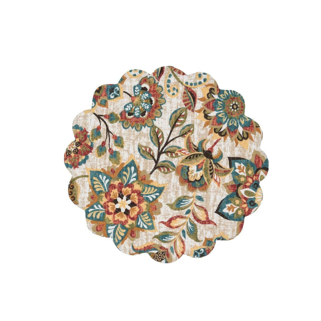 A round scalloped quilted placemat on a white background.  The pattern is of flowers and leaves in hues of ochre, tomato, blue, green and brown.  