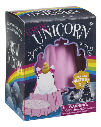 A photo of a toy 'Grow Unicorn' in its box.  The box shows a unicorn sitting in a pink stump next to a window in the box showing the real pink stump.  To the right of the window is a drawing showing the unicorn growing.
