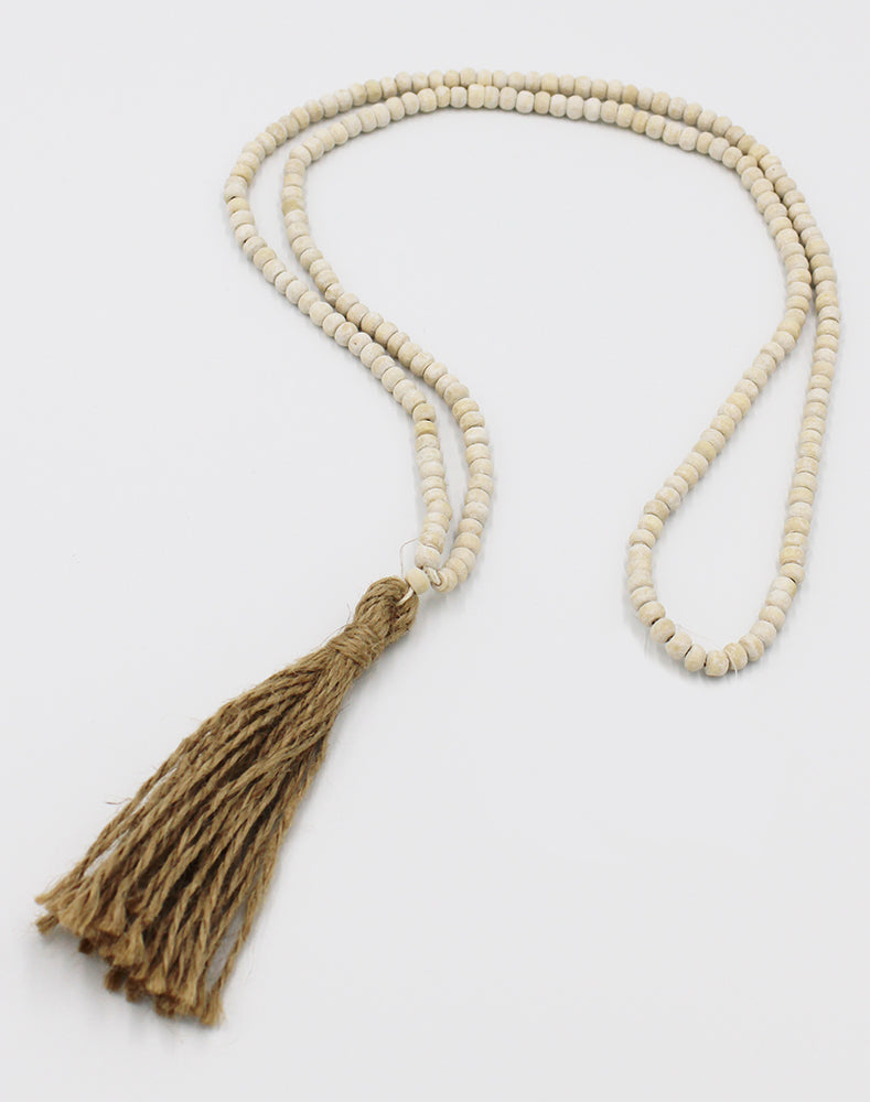 Long rope of white wooden beads with twine tassel at the end.