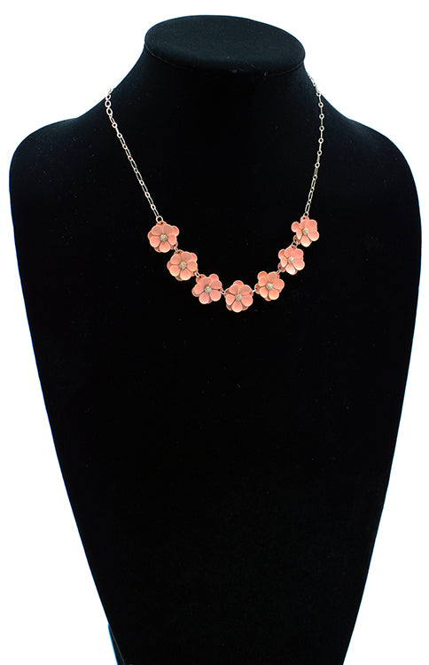 Seven peach matte flowers linked together with gold detail on a 6" chain with 3" extender