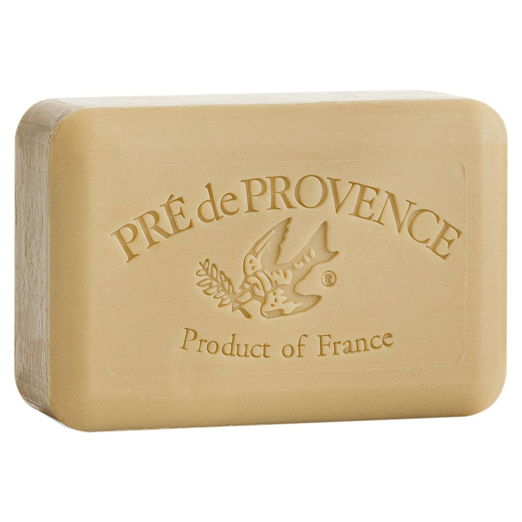 A tan bar of soap on white background.  A bird with a stem of greenery in its mouth is embossed in the center.  Text above the bird says 'Pre de Provence'.  Text below the bird says, 'Product of France'.