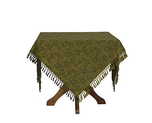 Green jacquard table cloth with fringe on a table.  Pattern is of peonies and accompanying leaves.