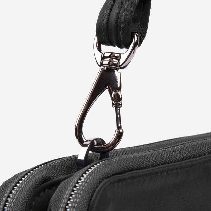 A close up detail of a shiny caribeaner clasp on the strap of a black purse.