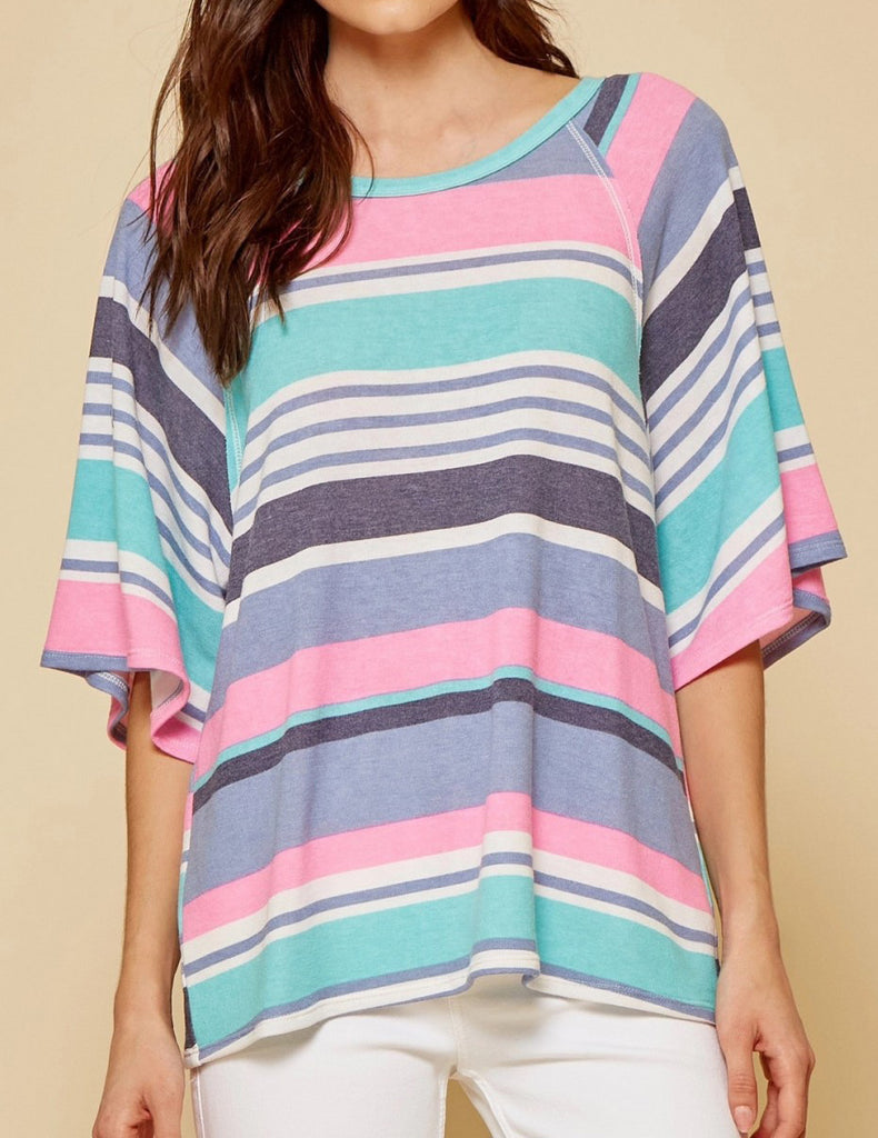 Front view of model wearing a slightly oversized striped top.  Top has alternating thin and thick stripes in pink, teal, gray, purple and white.