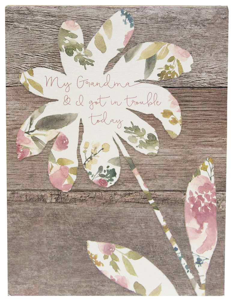 Grandmothers can be the best influences!  This Grandma Block Sign is made of wood with 1.5" sides and a hollow back. It features a wood texture background, with a cream silhouette of a flower with a floral pattern and a handwriting font in the middle that reads:  My Grandma & I got in trouble today