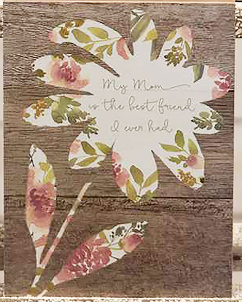 This block Sign is made of wood with 1.5" sides and a hollow back. It features a wood texture background, with a cream silhouette of a flower with a floral pattern and a handwriting font in the middle that reads:  My Mom is the best friend I ever had