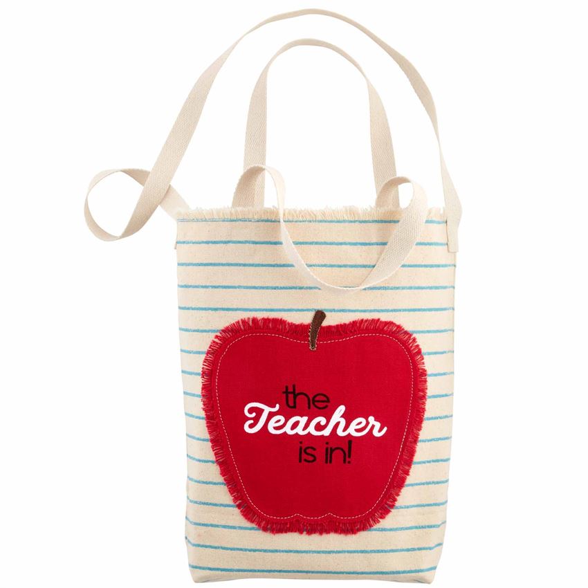 Cotton tote bag with handles.  Face of bag has blue lines to look like a note book page with a gently frayed top.  An apple appliqué with frayed edges is stitched on the side with the text that says ' The Teacher is in!"