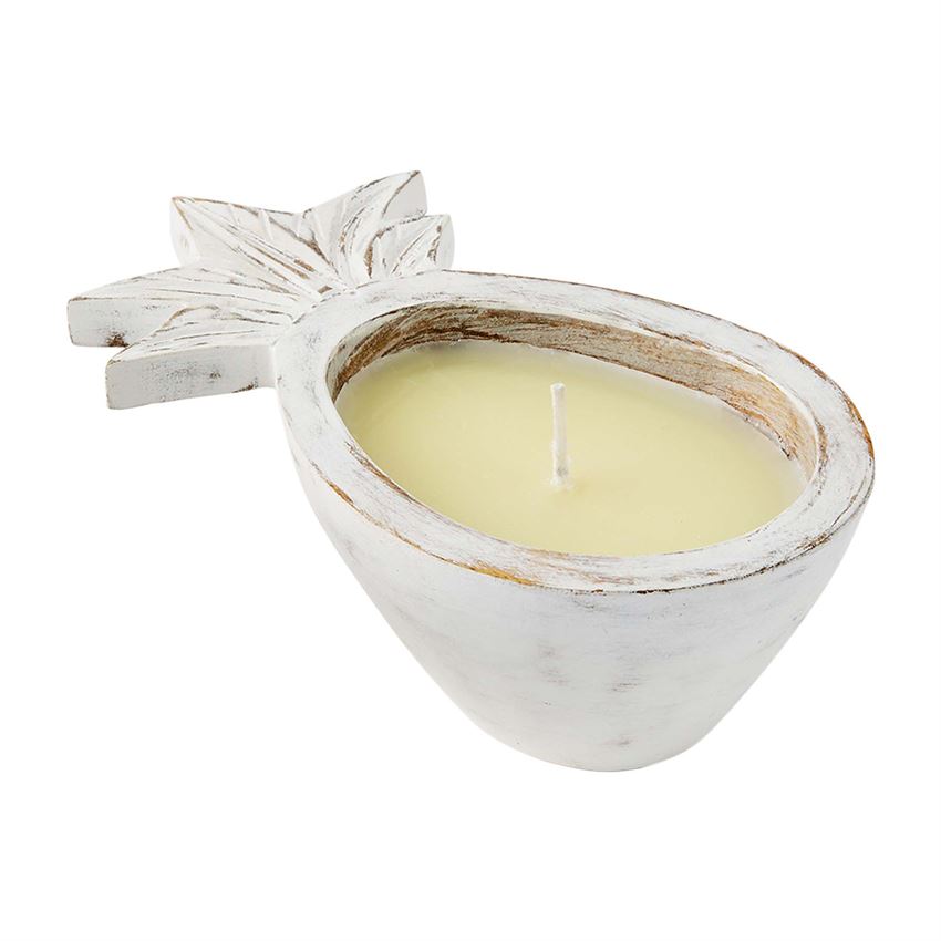 A wooden carved pineapple vessel with engraved detailing on the leaves, and an off white wax candle in the middle of the pineapple.  The finish of the wood has a white washed finish with minimal wood showing through.