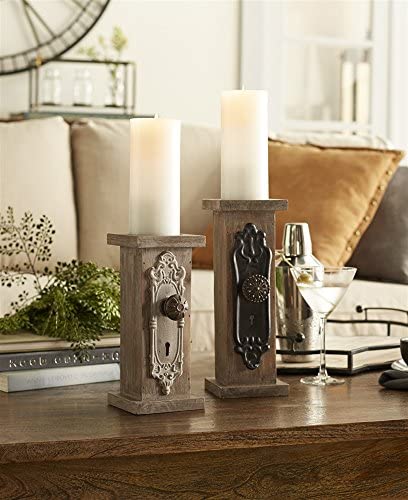 Two candle pedestals with door knob detailing on a table