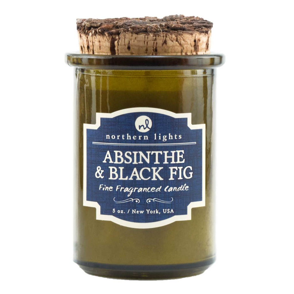A green glass jar candle on a white background.  The lid is a piece of burnt cork.  The label is blue with a cream border and says 'Northern Lights  Absinthe & Fig  Fine Fragranced Candle 5 oz. New York, USA'