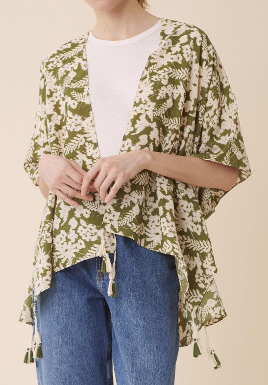 Front view of model wearing a green and white floral kimono over a white top and jeans.