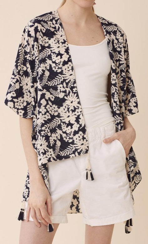 Front view of model wearing a navy and white floral kimono over a white top and shorts.