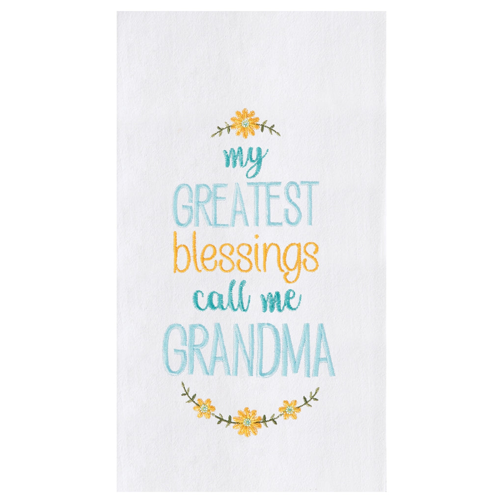 An image of a white kitchen towel with embroidered yellow flowers and blue and yellow text.  The text reads, 'my greatest blessings call me Grandma'.  Each line is in a different color and font.
