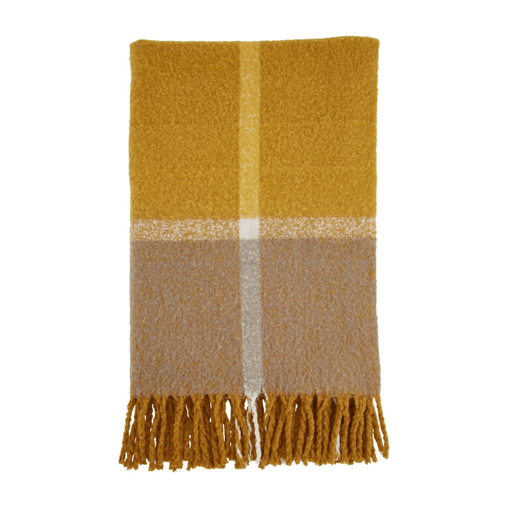 A blanket on a white background.  The blanket is folded in half and has a large color block pattern of mustard and gray on it, with a vertical and horizontal white line, quartering the pattern.  The blanket has dark gold tassels along the bottom.
