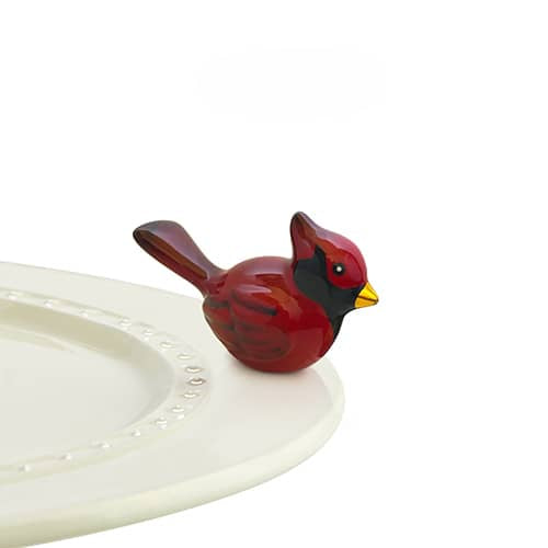 A ceramic cardinal attached to the edge of a tray.