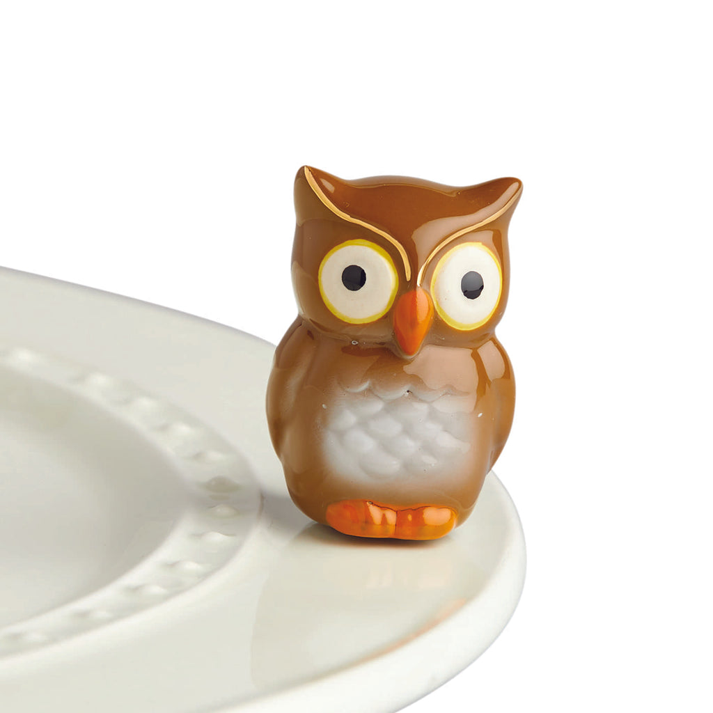 A ceramic brown and white owl attached to the edge of a tray.