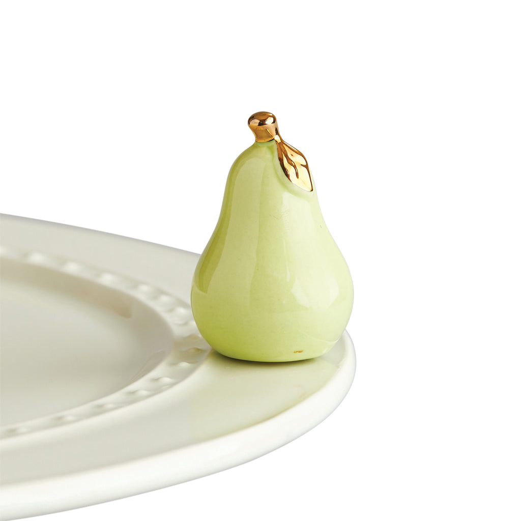 A ceramic pear with gold foil stem and leaf, attached to a tray.