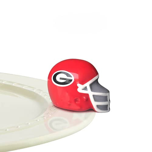 A ceramic red football helmet with a G in a white oval on the side - signifying the University of Georgia - attached to the edge of a tray.