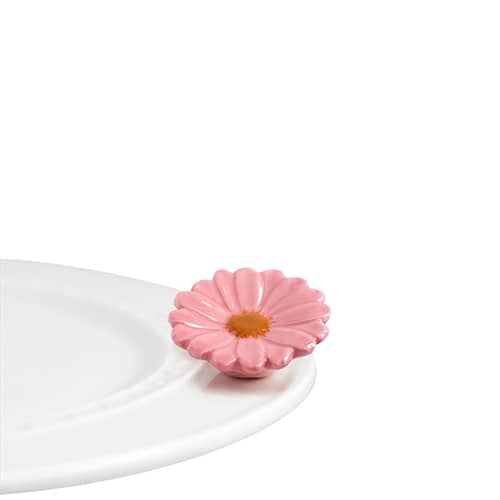 A ceramic pink flower attached to the edge of a tray.