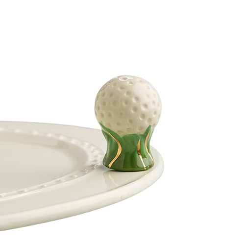 A ceramic golfball on a pillar of grass with gold foil accents attached to the edge of a tray.