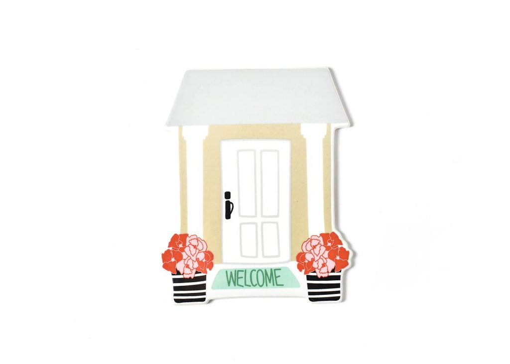 A ceramic flat cutout of a front porch with white door and green mat that says welcome.  On either side of the mat are a black and white striped vase of red and pink flowers.