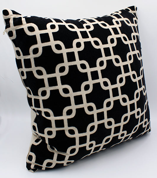 Tan pillow with raised black velveteen pattern creating interlocking squares across the front.
