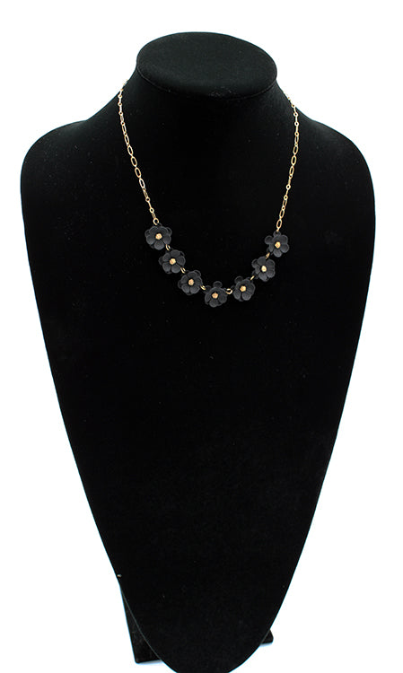 Seven black matte flowers linked together with gold detail on a 6" chain with 3" extender