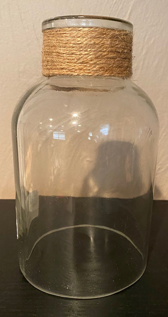 A wide bottomed cloche with a narrower neck that resembles a wide bottle.  The neck is short and is wrapped with twine.