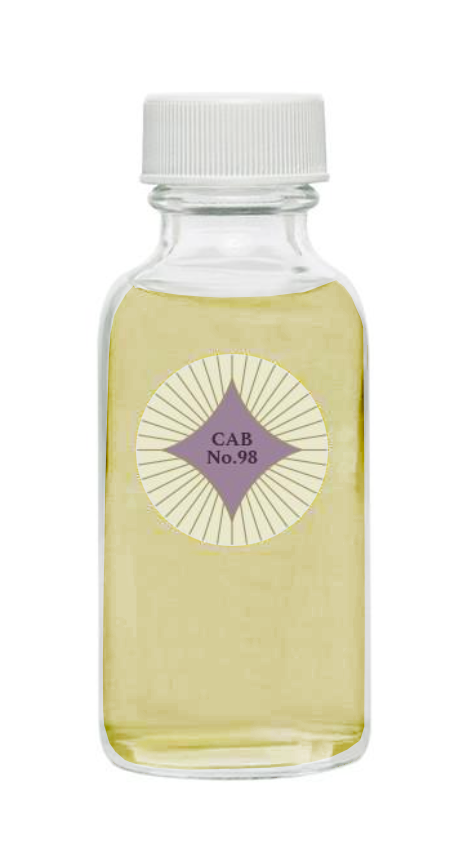 Container of Cabernet No. 98 potpourri refresher oil.  Glass bottle has a white cap and a round circular label.  The table has a purple 4 point star with rays radiating from it.  