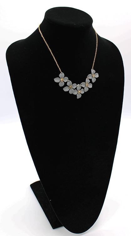 Five matte flowers linked together with gold detail on a 6" chain with 3" extender