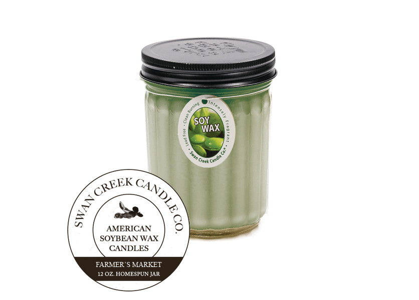 An image of a candle in a glass jar with a black lid.  The candle is green.  A graphic seal in front of the candle says 'Swan Creek Candle Co. American Soybean Wax Candles Farmer's Market 12 oz. Homespun Jar'.  The candle also has an ovular white label attached by a string wrapped under the lid.  The label has an image of green soybeans and says 'Soy Wax' along with 'Lead Free, intensely fragrant, clean burning'