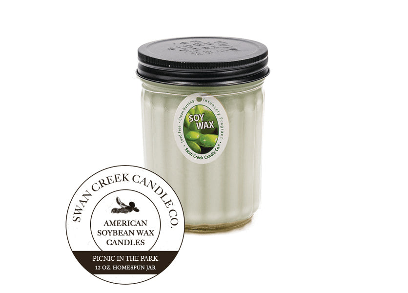 An image of a candle in a glass jar with a black lid.  The candle is light green.  A graphic seal in front of the candle says 'Swan Creek Candle Co. American Soybean Wax Candles Picnic in the Park 12 oz. Homespun Jar'.  The candle also has an ovular white label attached by a string wrapped under the lid.  The label has an image of green soybeans and says 'Soy Wax' along with 'Lead Free, intensely fragrant, clean burning'