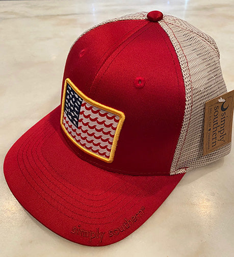 A photo of a baseball cap that is red in the front and has a red brim.  The back is a tan mesh.  The front of the cap has a yellow rimmed patch of a stylized American flag featuring fish silhouettes as the stars and waves as the stripes.  Simply Southern is also embroidered on the corner of the brim.