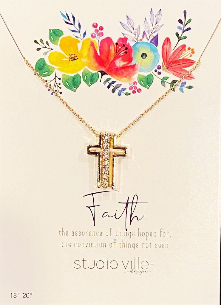 An image of a gold chain necklace with three pendants on it, on a card with art of flowers and text that reads 'Faith the assurance of things hoped for, the conviction of things not seen. Studioville design.'  The three gold pendants on the chain form a Catholic cross when they are together, with a vertical row of cubic zirconias in the middle.