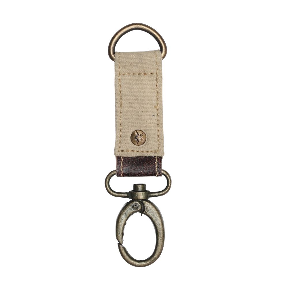 Canvas key fob with brass details, leather accent, and a rivet with a star embossed.  The canvas color is beige.