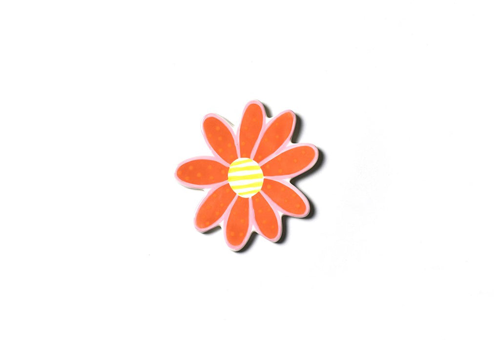 A flat ceramic cut out of a coral colored daisy, with polka dots on the petals and a yellow and white horizontal striped center.  The petals are outlines with pink.