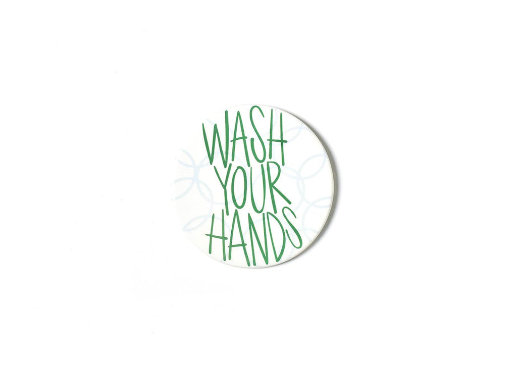 A flat round ceramic cut out that has a white background with light blue line circles implying bubbles.  On top of the bubbles is the text 'Wash Your Hands' in green all capital font.