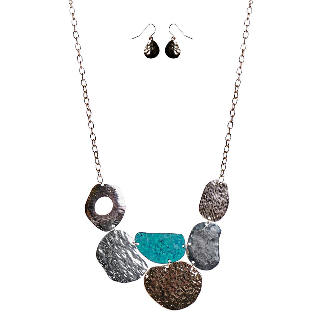A necklace and earring set.  The earrings are pear shaped and made of a hammered metal.  The necklace is composed of a variety of organic rounded shapes and the textures vary from hammered to striated.  They are of various metal finishes, silver and gold, and the one in the middle is turquoise.  