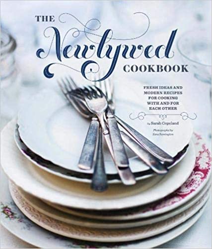 The book cover of "The Newlywed Cookbook" - shows a stack of plates with cutlery on top.  Text to the side of the plates says 'Fresh ideas & modern recipes for cooking with and for each other'