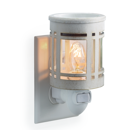 White metal wax melt warmer in the style of a mission light fixture, with clear glass showcasing the light bulb inside.