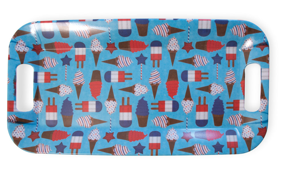 A tray on a white background.  The tray is rectangular with rounded corners and openings to be used as handles on the left and right sides.  The background of the tray is sky blue, and images of summer treats are printed all over the tray.  Images include soft serve cones with red, white, blue, or striped ice cream; rocket popsicles with two sticks, and red or blue star lollipops on striped sticks.