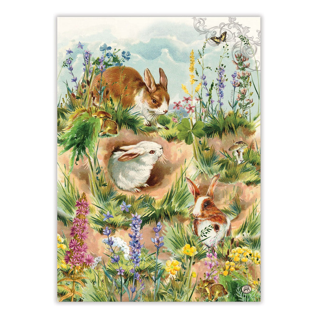 Kitchen towel with printed artwork of brown and white bunnies frolicking around a hollow.  They are surrounded by colorful spring flowers and butterflies.