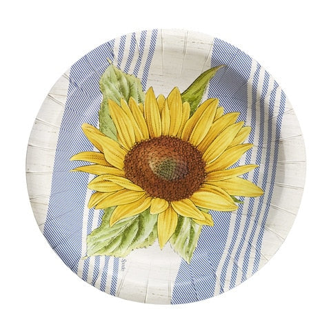 A round white paper plate with a series of blue stripes along the left and right sides of the plate.  The center of the plate has one large yellow sunflower.
