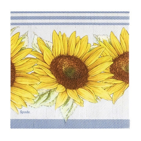 A square napkin on a white background.  The napkin has a printed image of three yellow sunflowers on a white background with three thin blue stripes above, and a thick blue border below.  The blue portions are made of diagonal blue and white lines.