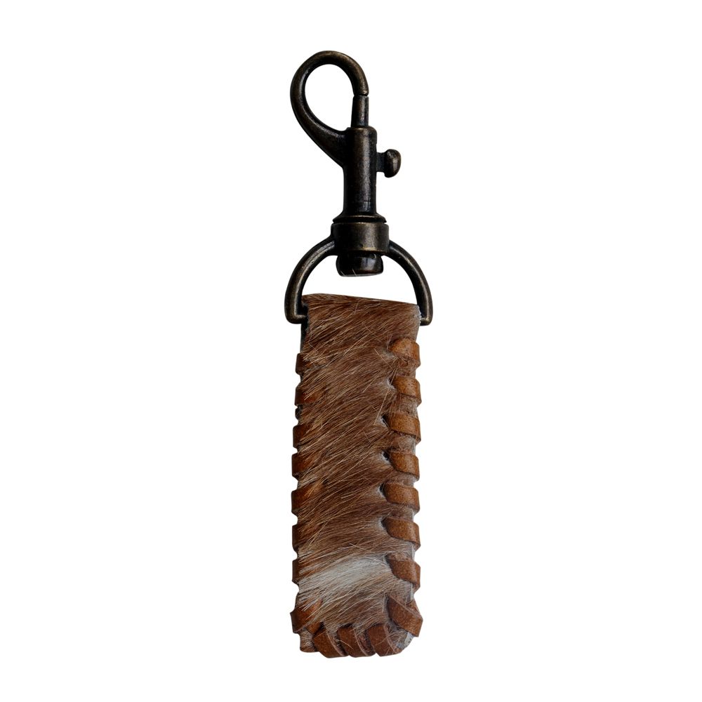 A brown and white cowhide strap keychain with laced leather around the perimeter.  Hide is attached to a dark brass keychain clasp.