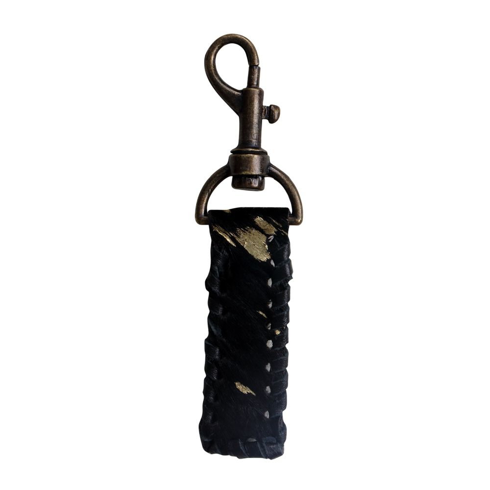 A black and gold cowhide strap keychain with laced leather around the perimeter.  Hide is attached to a dark brass keychain clasp.